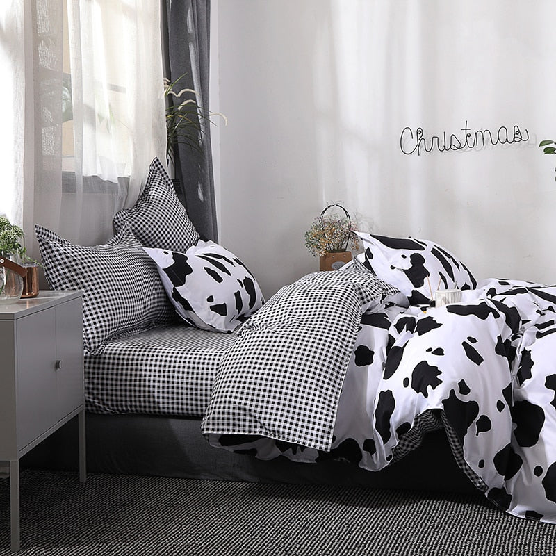 Full side view of the VibeCore Cow Print Bedding Set, highlighting the interior duvet cover with a black gingham pattern. Made from a soft cotton-polyester blend, this bedding set features a trendy mix of cow print and gingham, offering a stylish and cozy addition to your bedroom décor.