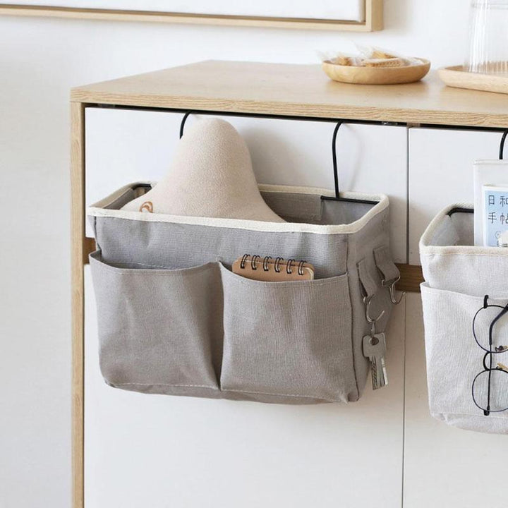 Close-up of light gray VibeCore bedside caddy with multiple pockets and hooks, designed for storing essentials like phones, tablets, and books. Durable and portable, perfect for small spaces like dorms and apartments.