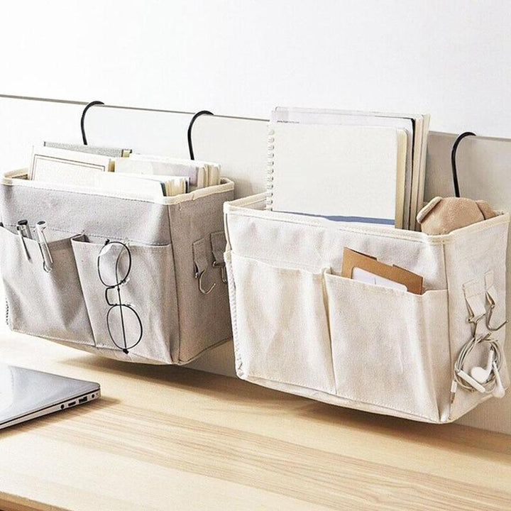 Space-saving light gray and white bedside caddy with multiple pockets and hooks for storing essentials like phones, tablets, and books. Durable, portable, and easy to hang over your bed or furniture, ideal for small spaces like dorms and apartments.