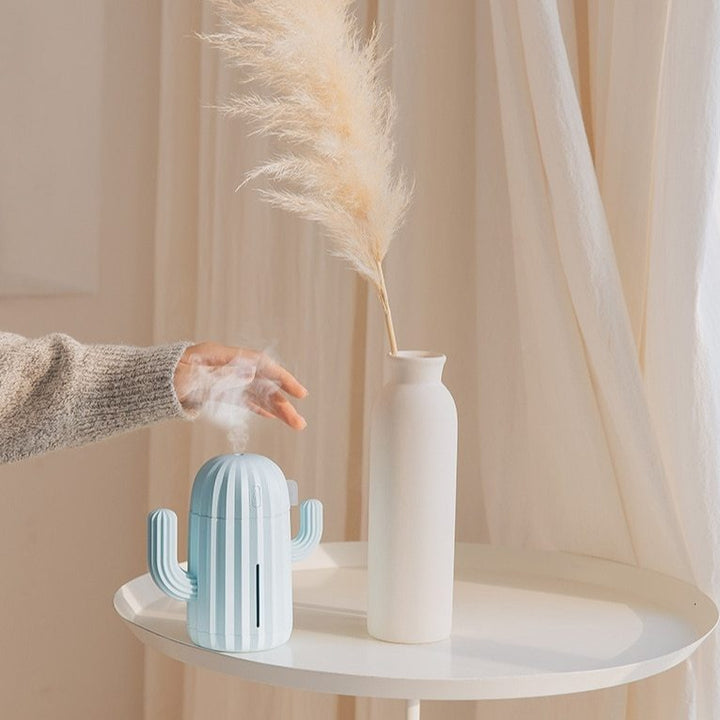 VibeCore Cactus Humidifier sky blue on side table with mist, featuring a playful cactus design, 340ml tank, and quiet operation, perfect for refreshing and enhancing any space.