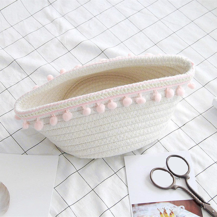 VibeCore Cotton Rope Storage Basket in light pink, handmade with natural cotton and jute, placed on a bed, perfect for organizing and adding a soft, stylish touch to your room decor.