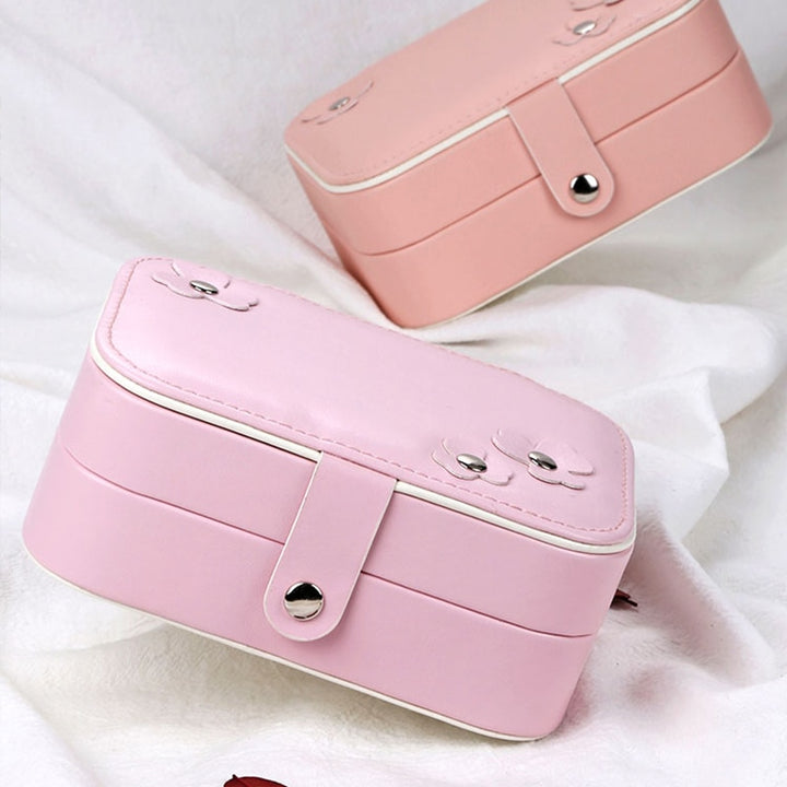 Both colors closed, showcasing compact design and durable synthetic leather exterior. Ideal for storing jewelry securely and stylishly on the go.