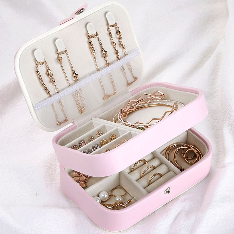 Compact and stylish jewelry organizer with two layers, featuring compartments for rings, necklaces, and earrings. Soft velvet interior and durable synthetic leather exterior, ideal for travel or everyday use.