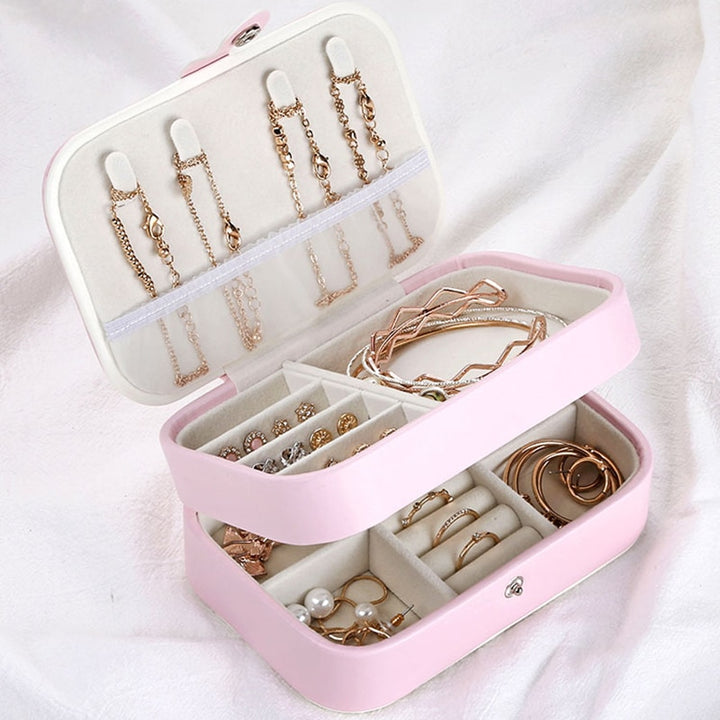 Compact and stylish jewelry organizer with two layers, featuring compartments for rings, necklaces, and earrings. Soft velvet interior and durable synthetic leather exterior, ideal for travel or everyday use.