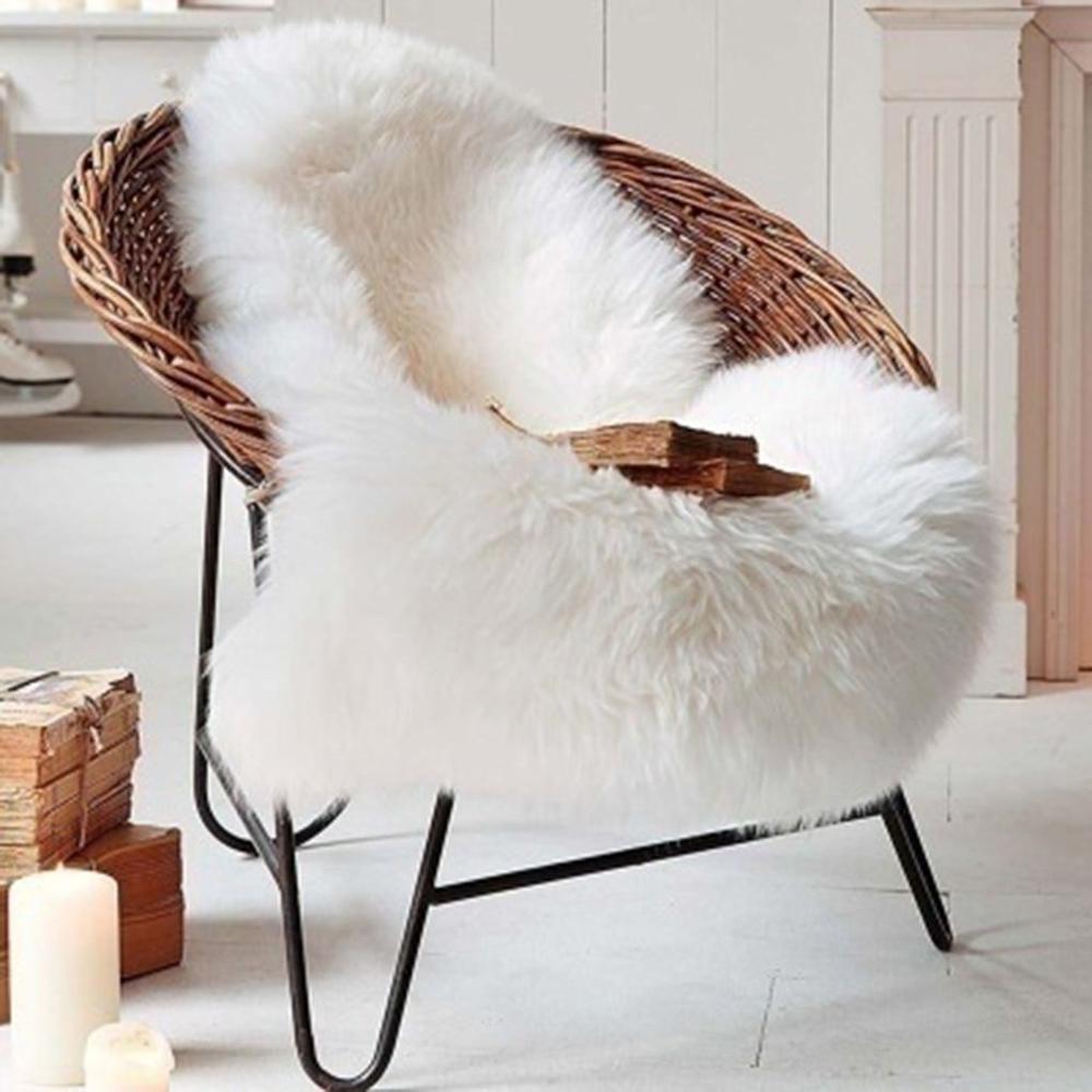 VibeCore Faux Sheepskin Rug/Chair Cover white, draped elegantly on a chair, showcasing its soft and fluffy texture, perfect for adding warmth and style to any room.