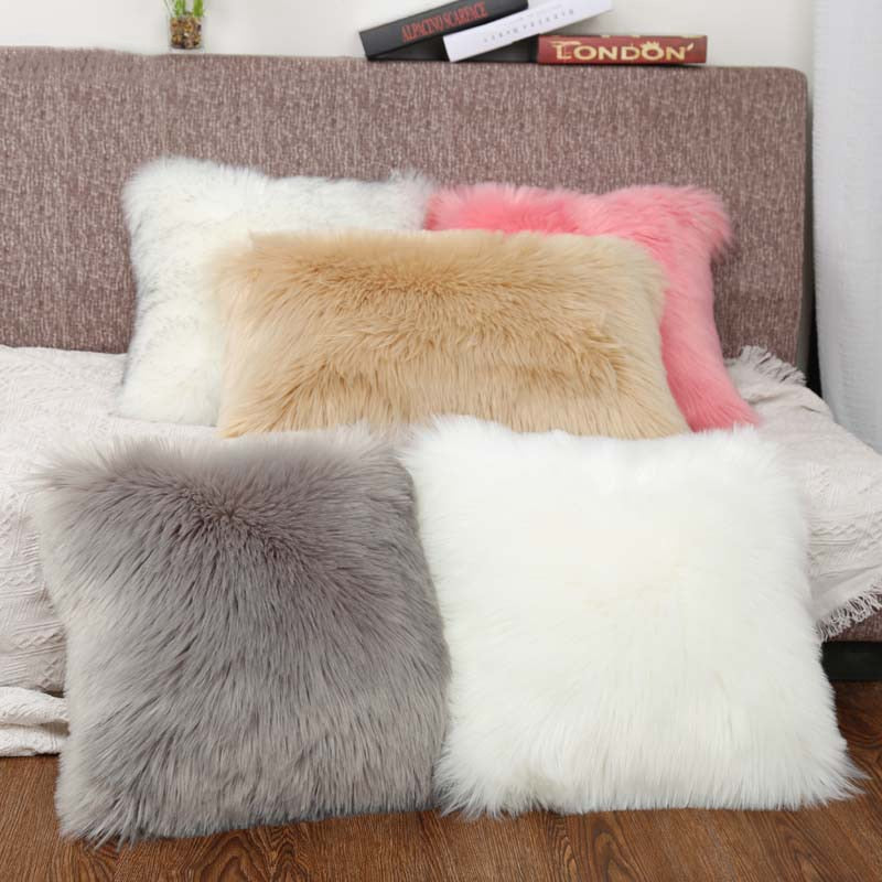 VibeCore Fluffy Faux Fur Pillow Case in 5 colors arranged on a bed in a bedroom, highlighting the soft, cozy texture and vibrant hues.