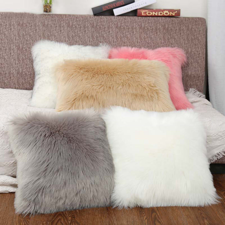 VibeCore Fluffy Faux Fur Pillow Case in 5 colors arranged on a bed in a bedroom, highlighting the soft, cozy texture and vibrant hues.