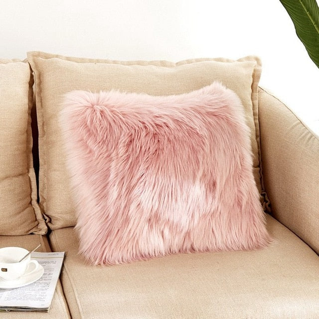 VibeCore Fluffy Faux Fur Pillow Case in light pink, showcasing its soft and cozy texture placed on a couch.