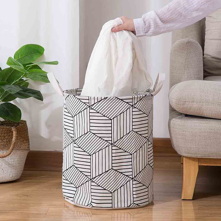 VibeCore Foldable Abstract Laundry Basket with laundry being taken out, featuring a large-capacity, waterproof, and dustproof design with reinforced handles for easy carrying.