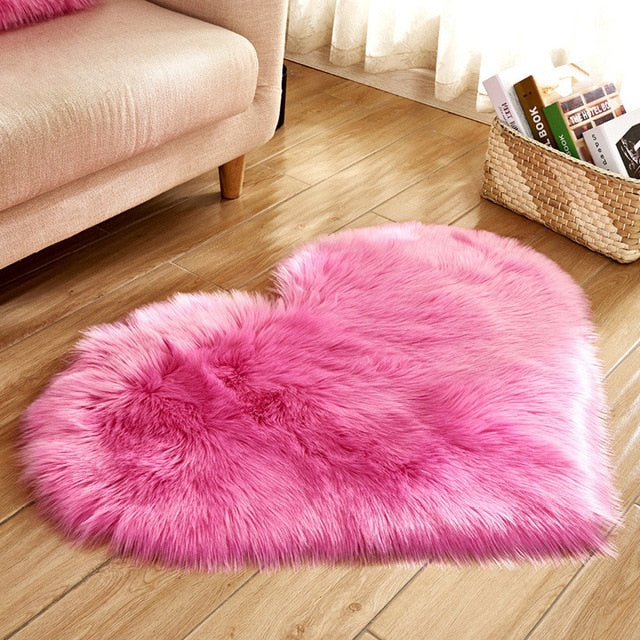 VibeCore Heart-Shaped Accent Rug in pink, featuring a soft faux sheepskin texture with a non-slip backing, ideal for creating a cozy, romantic vibe in bedrooms, dorms, or living spaces.