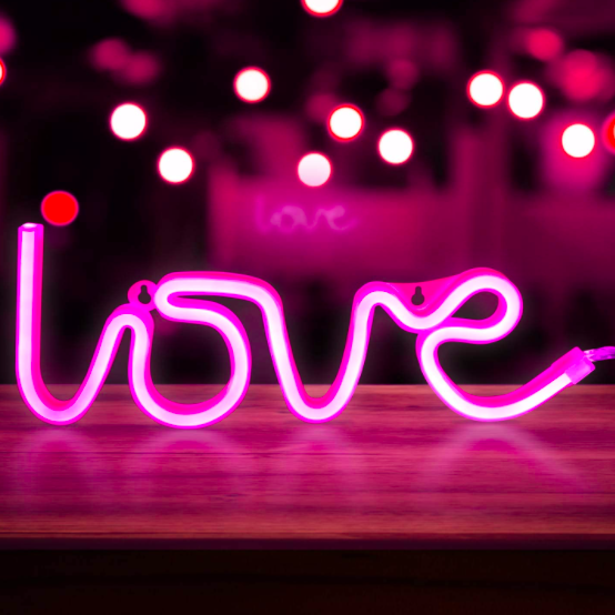 Aesthetic VibeCore Love Neon Light in pink on a table, USB or battery-powered LED sign for trendy bedroom, dorm, or lounge decor, creating a warm, romantic glow to elevate your space.