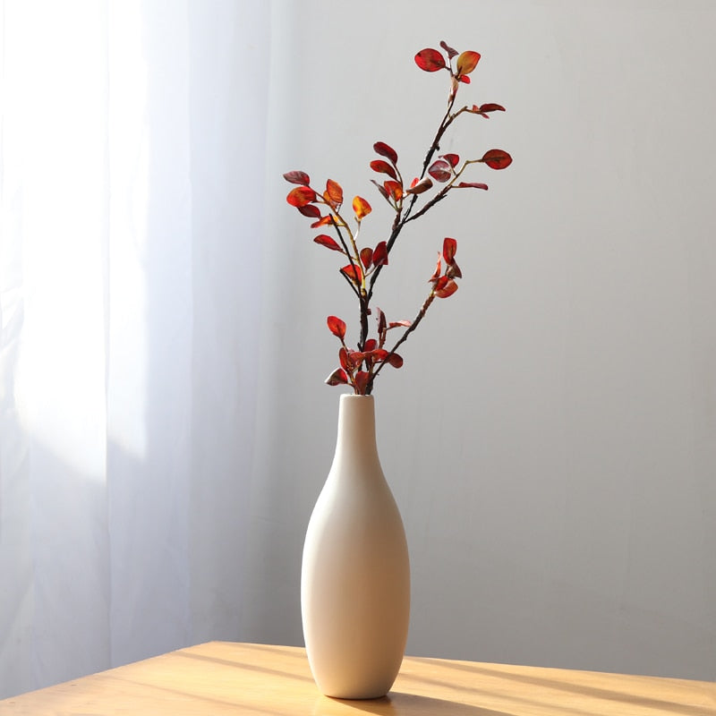 VibeCore Matte White Ceramic Flower Vase on table, showcasing a minimalist tube design, perfect for displaying fresh flowers and adding a modern touch to any room decor.