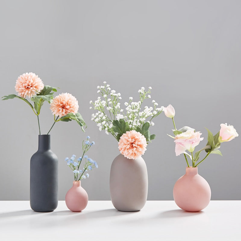 VibeCore Nordic Ceramic Vases in all four colors with flowers arranged inside, showcasing a modern minimalist aesthetic for home or apartment decor.