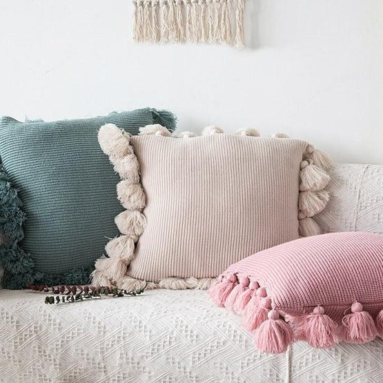 VibeCore Nordic Style Hand-Knitted Pillow Covers in Blossom, Dark Gray, and Turquoise Blue arranged on a couch, showcasing boho fringe details and cozy textures.