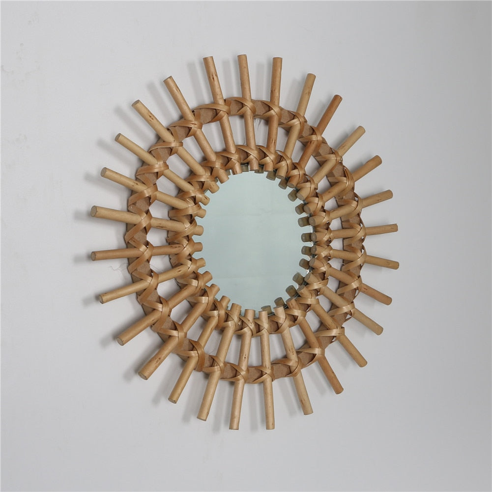 VibeCore Rattan Sun Mirror angled view, showcasing the natural rattan frame and the reflective glass surface with a hint of the sunburst design.