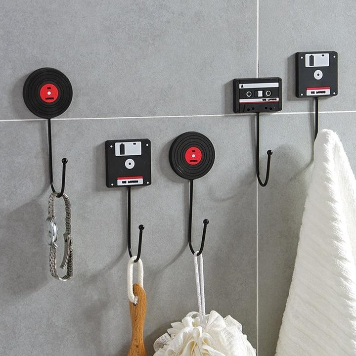 VibeCore Retro Wall Hook set with floppy disk, vinyl record, and cassette tape hooks displayed on a bathroom wall, each holding a towel and adding a vintage touch to the space.