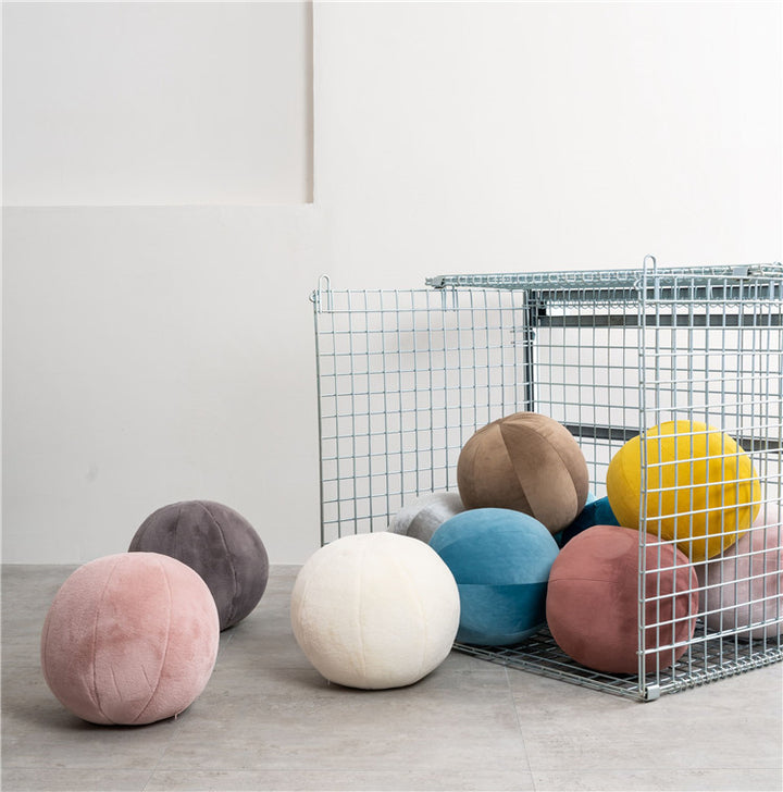 VibeCore Velvet Ball Pillows in a variety of colors displayed inside a decorative cage, showcasing soft, plush velvet round pillows in multiple shades for modern home decor.