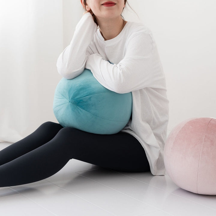 VibeCore Velvet Ball Pillow in light pink, girl holding soft round velvet pillow, showcasing plush, stylish decor for modern bedroom or living room.